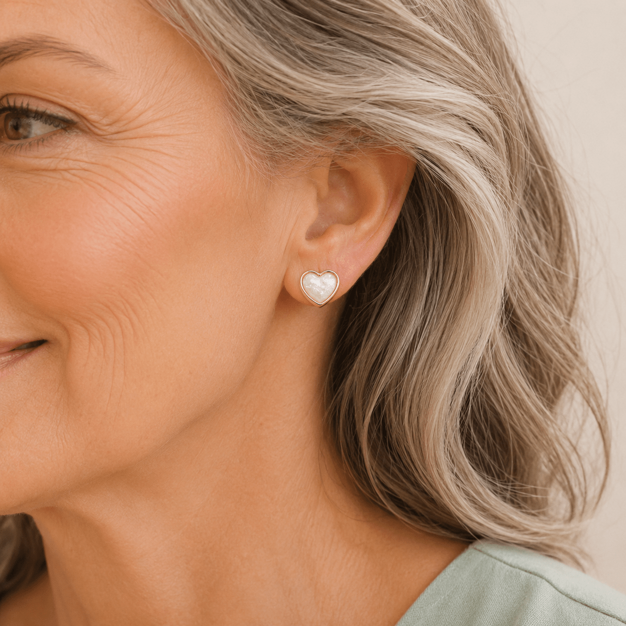 Heart shaped keepsake earrings on an older female model