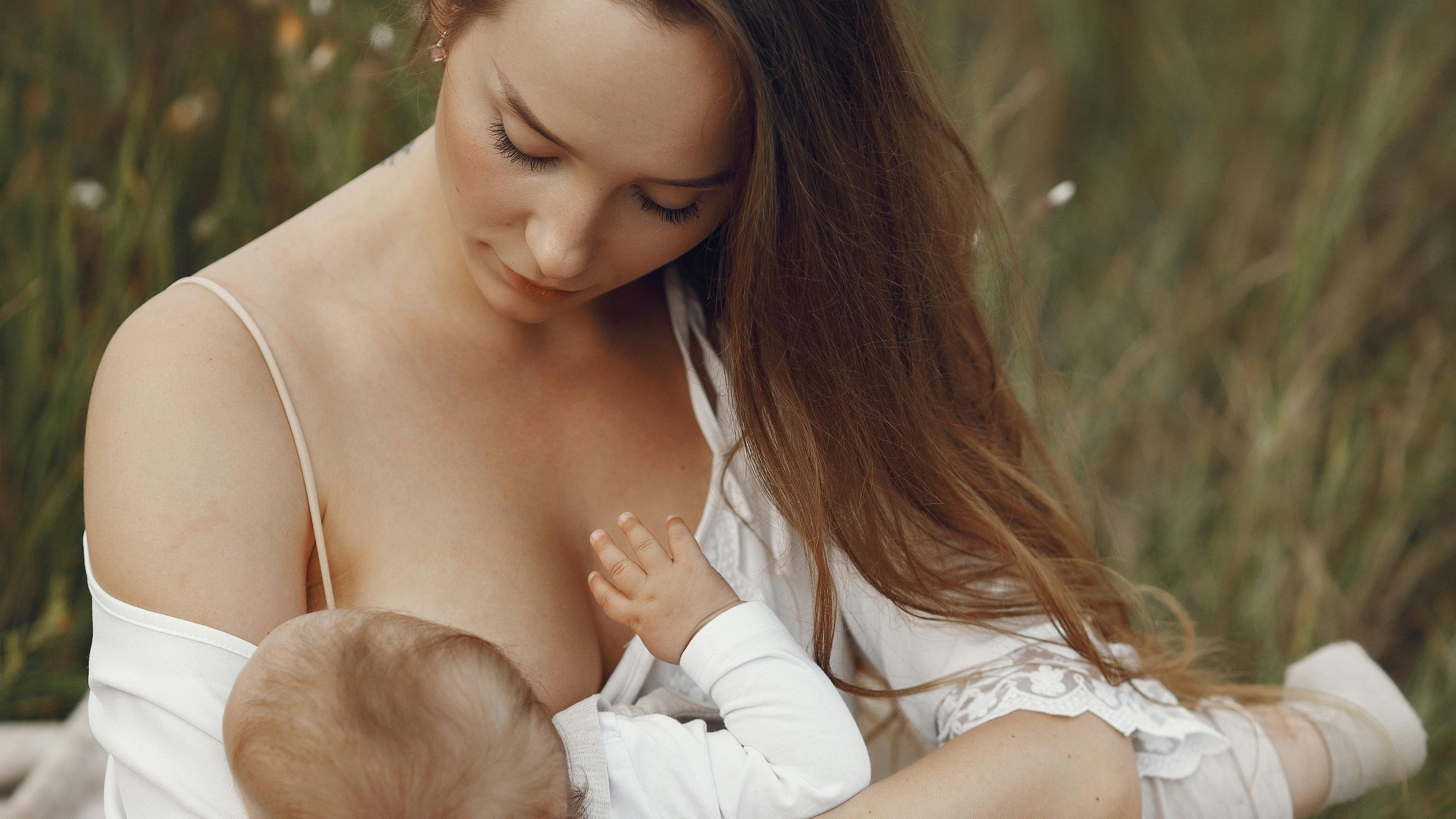 Woman breastfeeding a baby outdoors in a natural setting