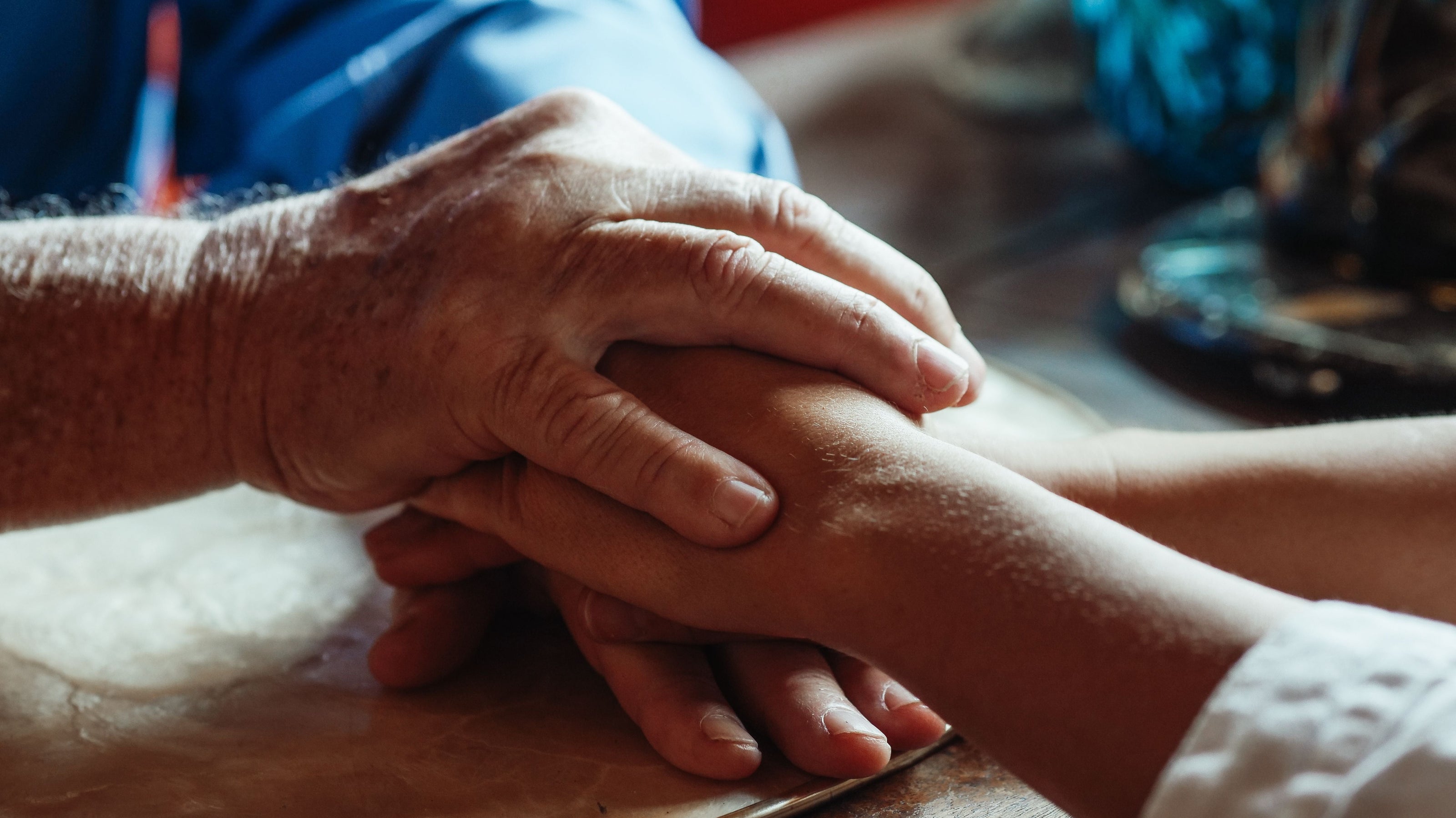 An older male holder the hand of a younger person