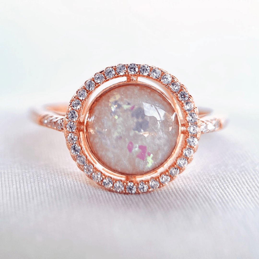 Lumina halo ring in rose gold. Round luminous breastmilk stone surrounded by a halo of CZ.